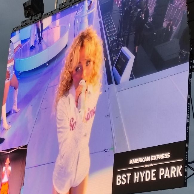 Sabrina Carpenter looking to camera at a Hyde Park gig