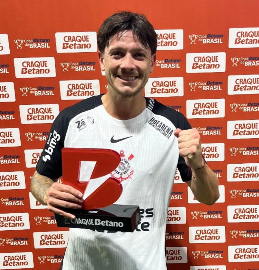 Rodrigo Garro, jogador do Corinthians, de uniforme, comemorando Com o troféu de craque do jogo na mão