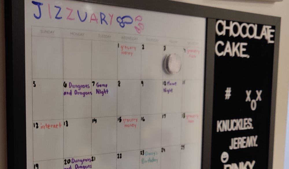 A whiteboard calendar. The month reads "Jizzuary" in alternating blue and pink letters. There is a blue penis on the end with pink squirts coming out.