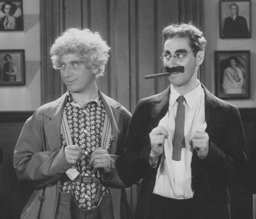 An image of Groucho and Harpo Marx from a black and white movie.