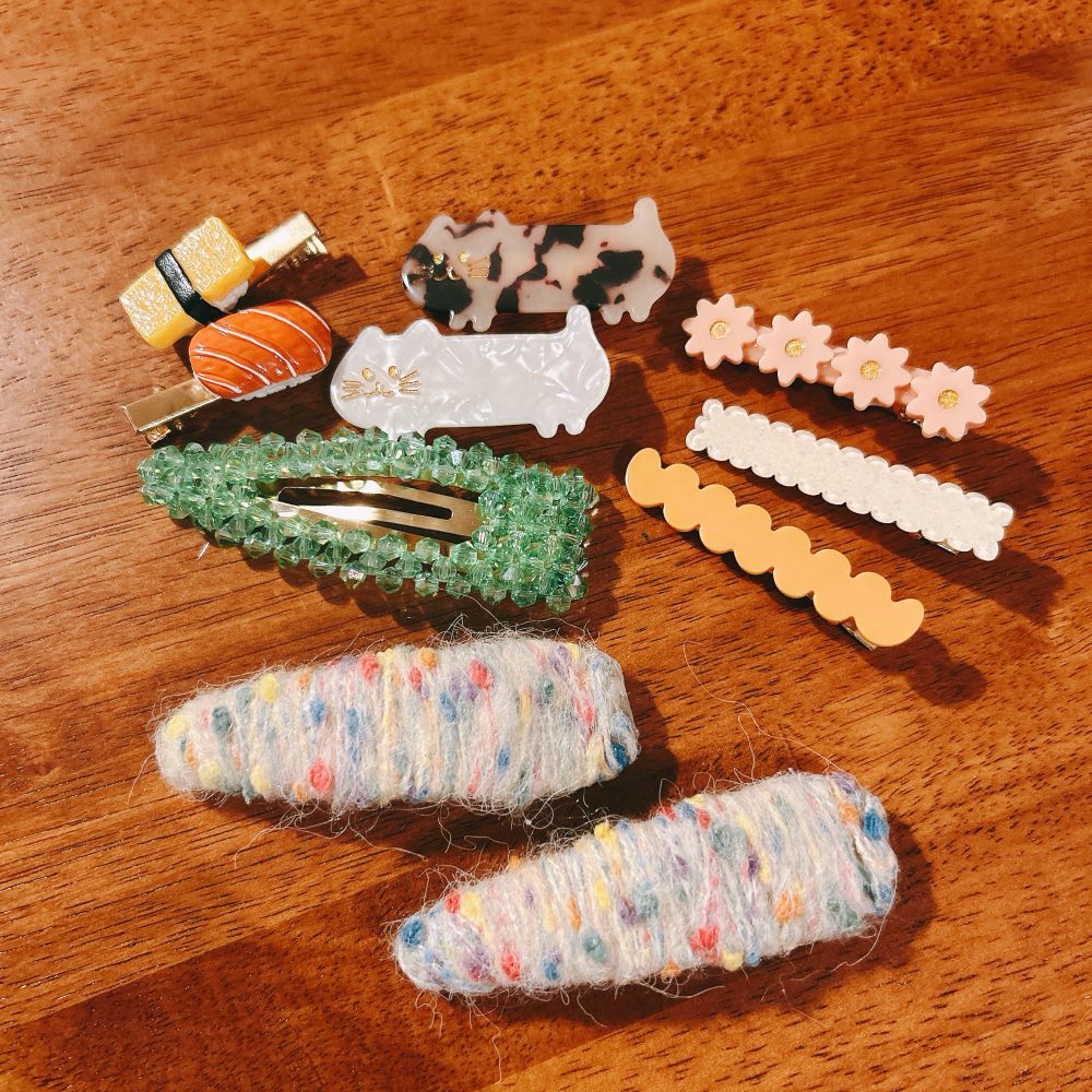 色とりどりのヘアピンたち。たまごやサーモンのお寿司がついているもの、猫型、ビーズでかたどられたものなど。