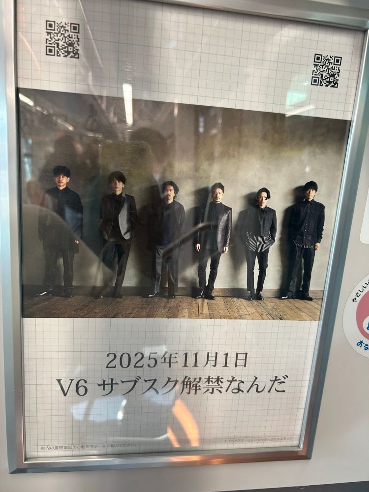 電車内の広告。V6の6人が黒を基調とした装いで横に並んでいる写真。写真の下に「2025年11月1日 V6サブスク解禁なんだ」と書かれている。