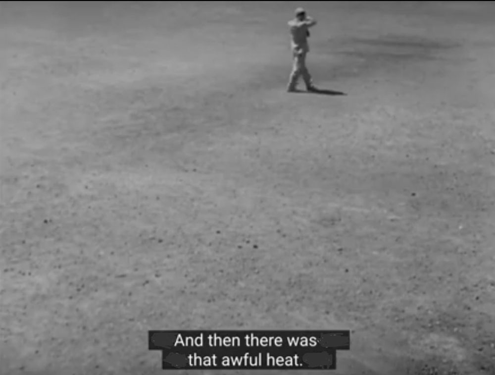 From Stray Dog, a shot of a man in a light suit walking across a sun-parched empty lot around midday. Voice-over caption says, And then there was that awful heat. 
