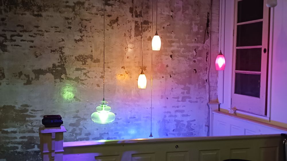 Multicolored image of pendant lights illuminating the syairwell at The Rabbit Hole.