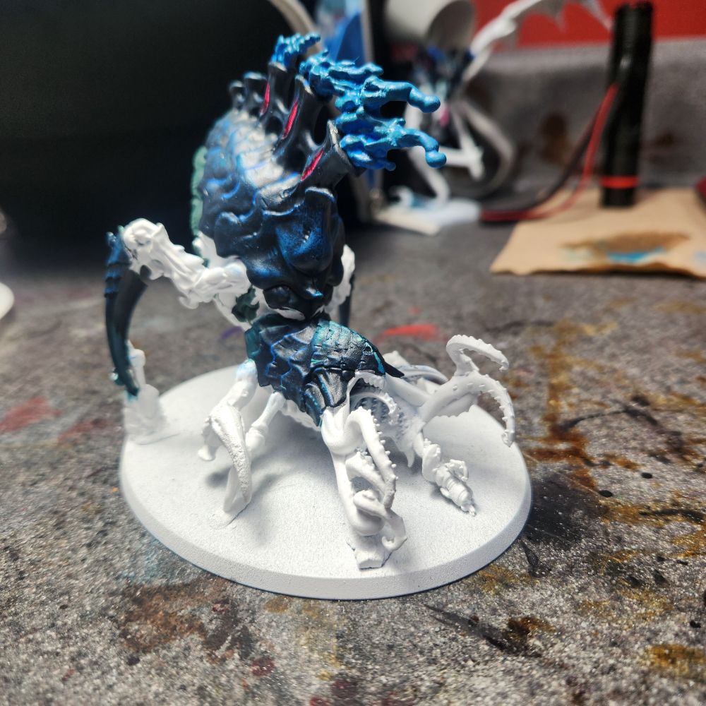 A psychophage from the game Warhammer 40k. It primed white with some part painted black, teal, different shades of blue and pink.