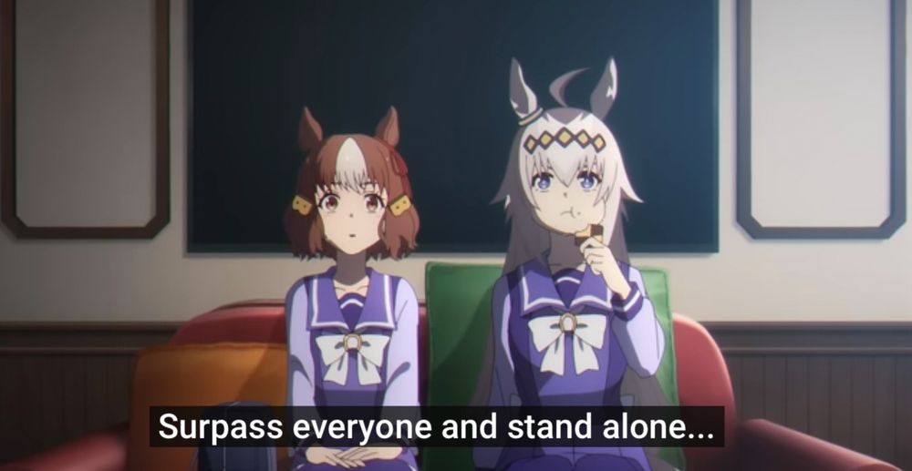 Belno (short brown hair and barrettes) and Oguri (gray hair with yellow diamond headband) sit on a couch facing Rudolph, with Oguri eating a cookie. Belno translates the phrase into Japanese, which the English subtitle translates to “Surpass everyone and stand alone” 