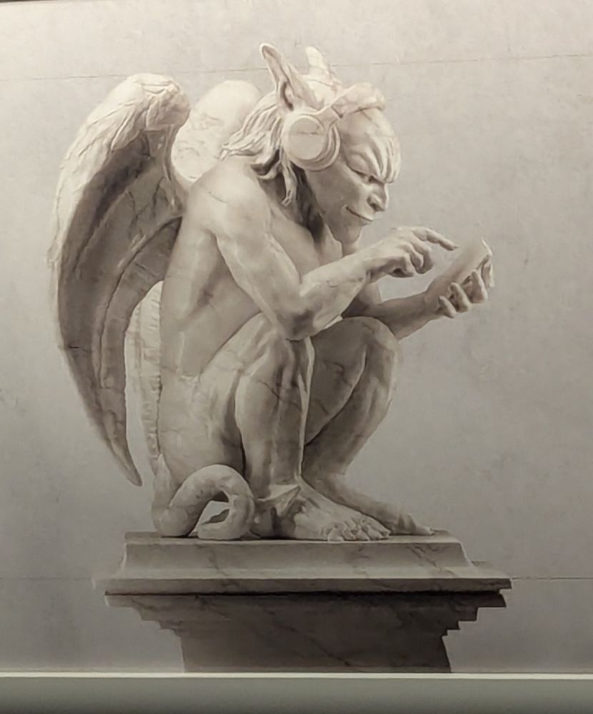 A photo of an ad on the subway, showing a classical sculpture of a demon wearing headphones and tapping with a finger at a phone