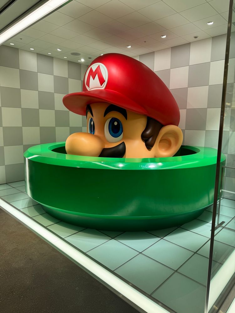 A statue of Mario in a green pipe at the Kyoto Nintendo store. 