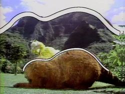 Snuffleupagus from Sesame Street being talked to by Big Bird.  The mountain behind them has the same silhouette as Snuffleupagus.