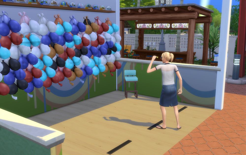 A screenshot from the Sims 4 showing a Sim playing a balloon dart game.