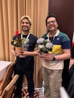 Sharang and NAS representative Nawar smiling and posing with plants 