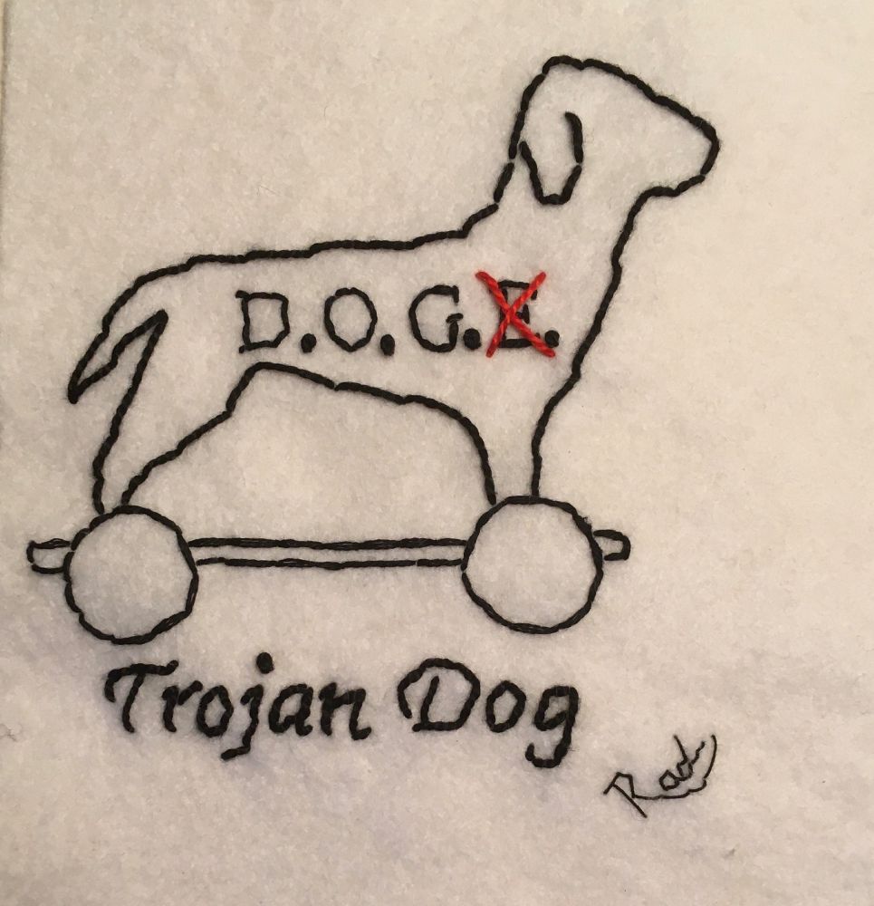 Embroidery of an outline of a dog on wheels with the initials D.OG.E. written on it with the E crossed out. The words Trojan Dog written underneath 
