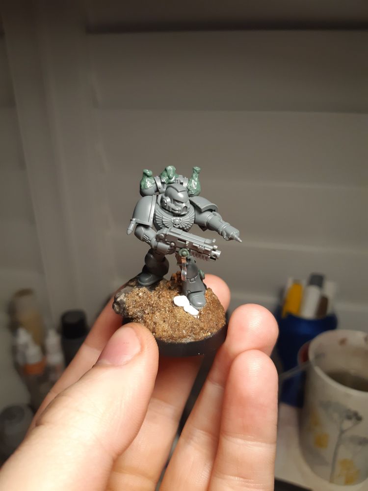 An unfinished space marine with a bolter.