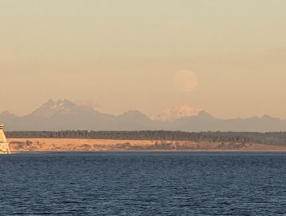 Orange-y photo of the moonrise over the Cascade Mountains