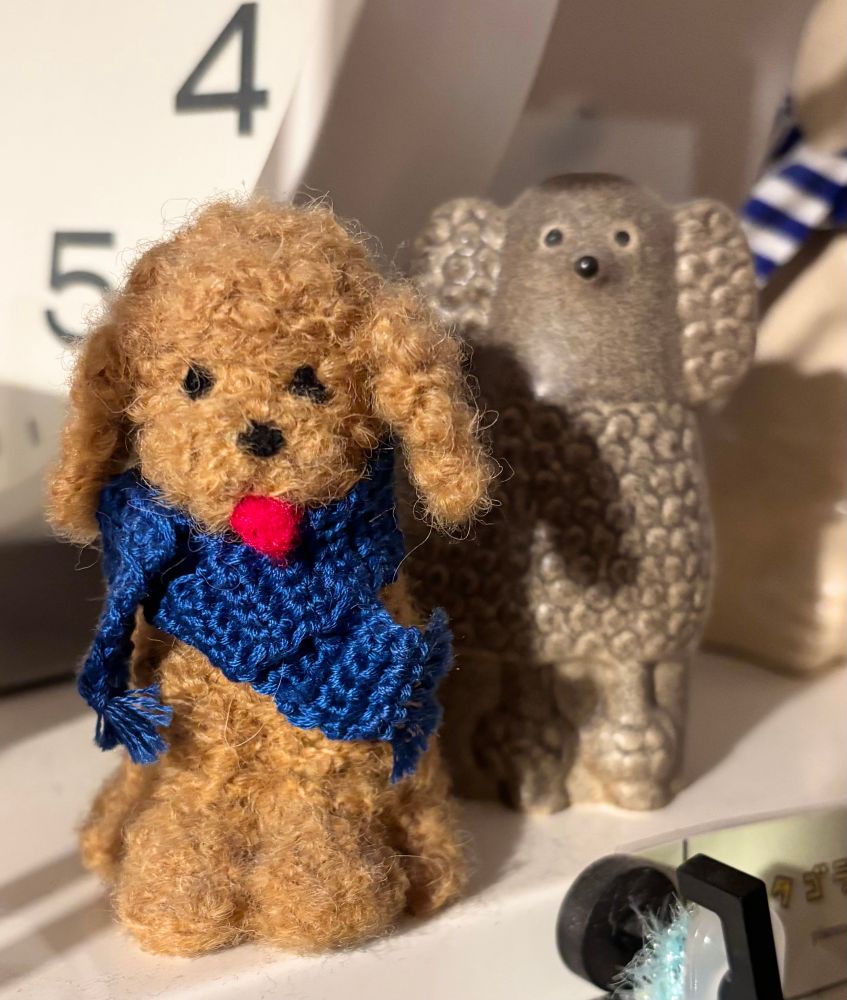 編み物を応援する気持ちでいっぱいのプードルのフェルトマスコットと、リサラーソンのベージュのプードルの置物。リサラーソンのプードルは目が点で鼻も点で、とてもかわいい。