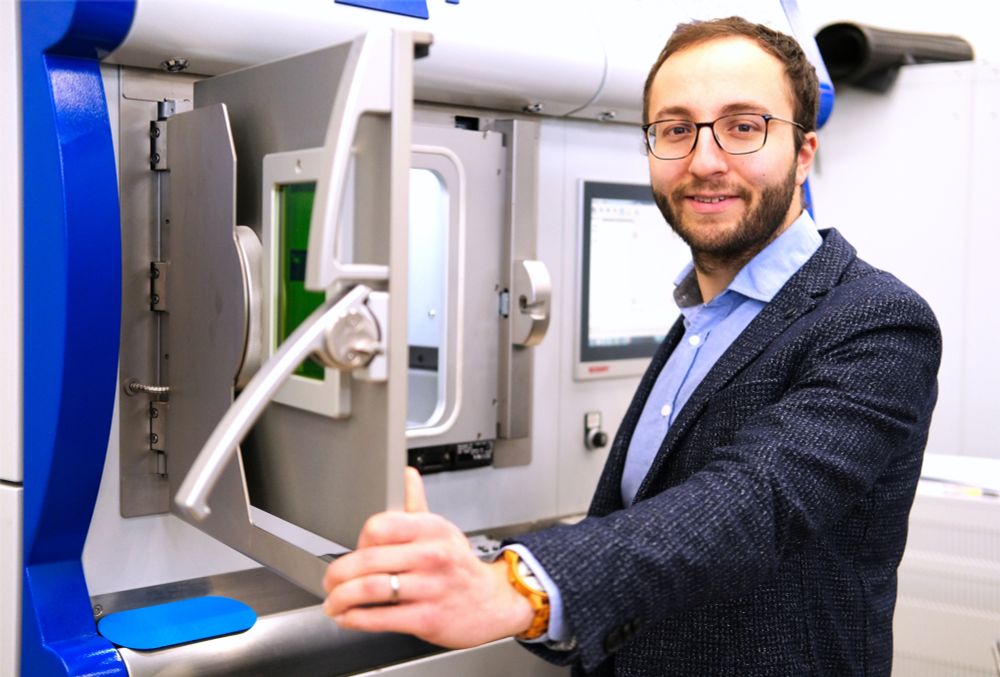 Oliver Maurer steht vor einem 3D-Drucker.