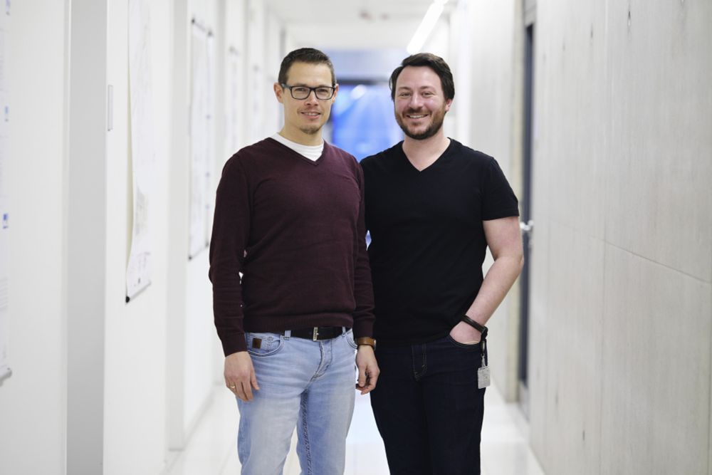 Zwei Forscher stehen in einem Flur.