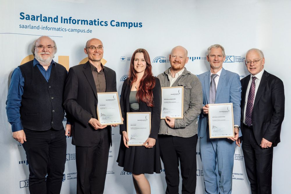 Gruppenfoto: DFKI-Standortdirektor Prof. Philipp Slusallek, Preisträger Tim Schröder, Dr. Sabrina Patsch, Moritz Metz und Ralf Krauter mit Minister Jürgen Barke (v.l.n.r.)