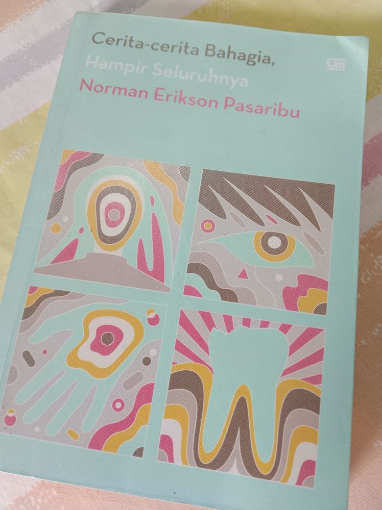The blue cover version of Norman Erikson Pasaribu's Cerita-Cerita Bahagia, Hampir Seluruhnya. The cover art features four squares with colorful shapes inside each of them: a human body, an eye, a hand, a tooth. 