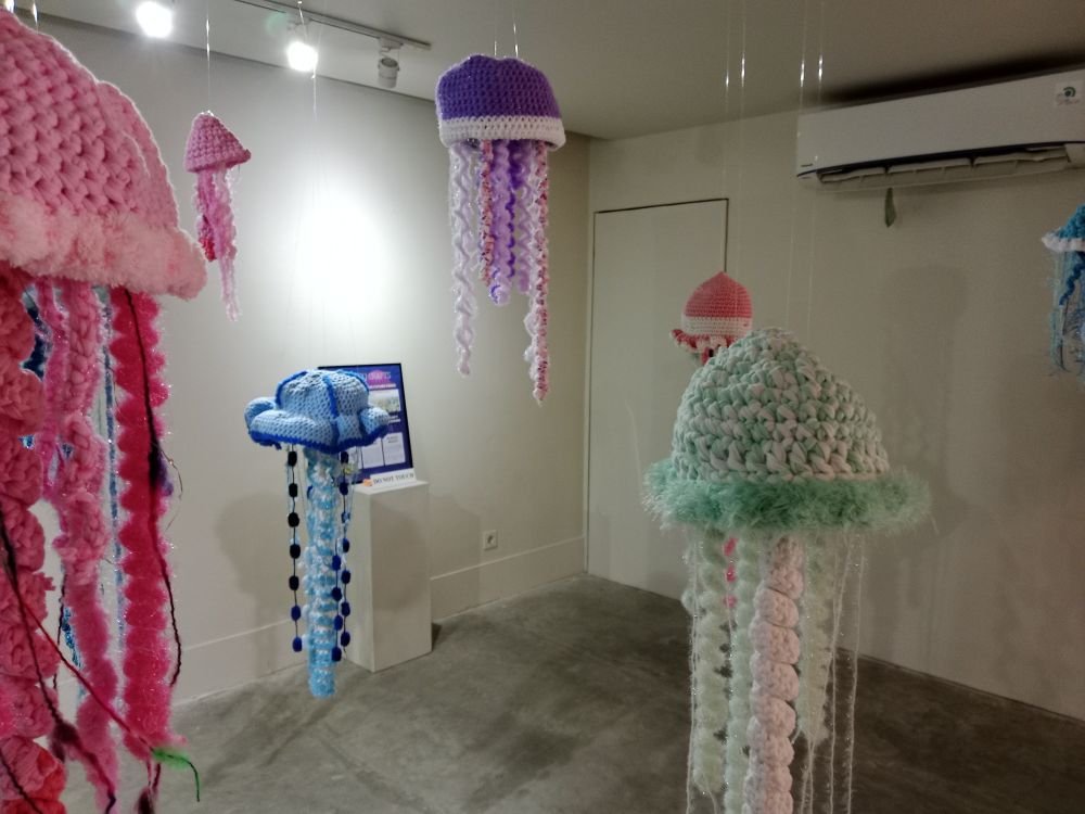 The jellyfish (blue, purple, red) from another angle, with white walls and the air conditioner in the background. 