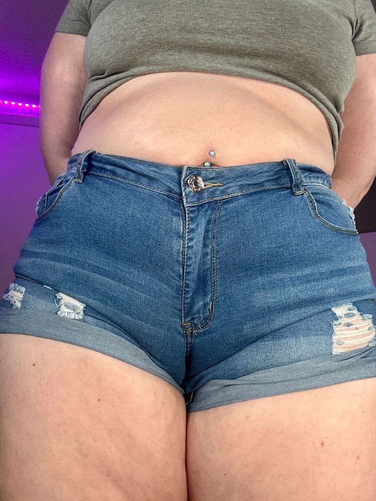 Picture shows op standing directly in front of the camera in a pair of daisy duke jean shorts. The shorts are revealing their thick thighs. The tight shorts tightly hug OP’s juicy hairy cat and form a perfect camel toe making you drool. Their round belly and pierced belly button slightly hang over the top of the shirts accentuating the yummy honey pot below. This camel toe is your kryptonite. 