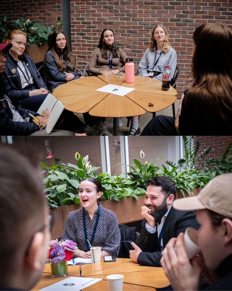 Mehr Fotos von Studierenden, die um einen runden Tisch sitzen, lächeln und zuhören.