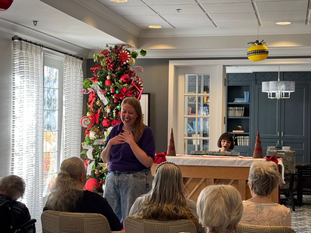 A woman sings to a group of seniors.