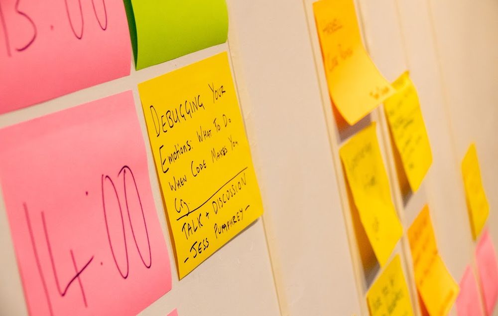 Photo by Esko Luontola: Closeup of a whiteboard filled with post-it notes, each of which describes a conference session proposed by a member of the conference.