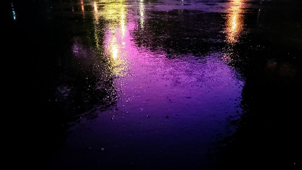 Purple sunset reflected on rain-soaked asphalt 