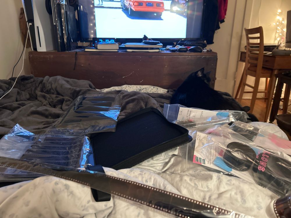 A mattress with 35mm film spread out and a binder with sheets of film inside of it. 