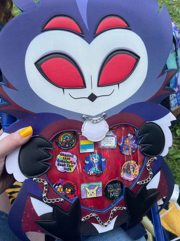 Stolas Ita bag displaying various pride pins 