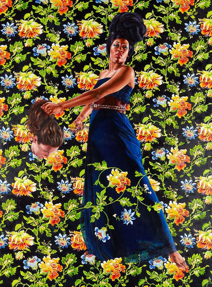 An oil painting, an adaptation of the artistic trope of Judith and Holofernes. On a vibrant patterned floral background, a Black woman (in the role of Judith) with an elaborate wrapped hair style, Navy blue dress, and leather belt ornamented with a metallic chain band, stands with her weight on her right foot, her left leg outstretched forward. One vine of the floral background crosses horizontally over the bottom center of her dress. She twists at the waist, but with her back straight, so that her left arm stretches across the foreground. In her left hand, the severed head of a white woman with wavy brown hair (Holofernes). The Black woman wears a purple and blue ombré eyeshadow, her gaze firm and directly at the viewer.