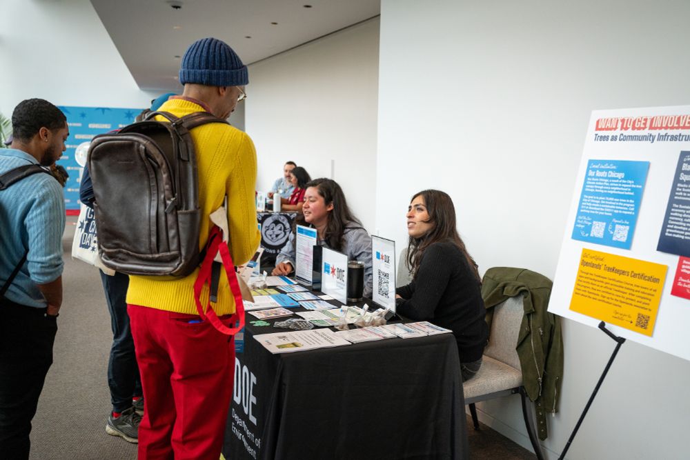 People conversing at a Chicago Department of Environment resource table at an event.