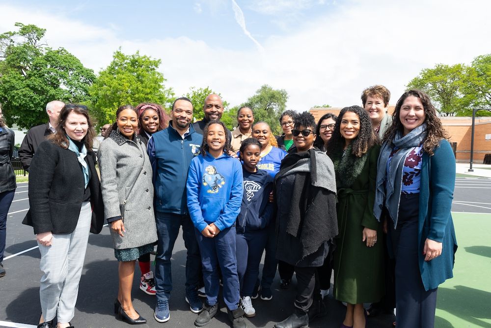 Group of people posing together at an outdoor event, smiling.