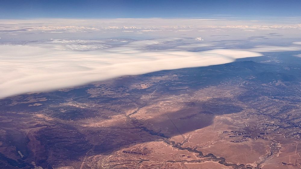 an expansive but thin white cloud with gentle edges floating over the Utah desert 