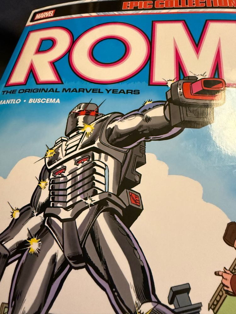 Marvel Epic Collection: Rom: The Original Marvel Years Vol. 1 book. 
The cover depicts the Spacekight Rom aiming his neutralized at emeries attacking him whilst citizens are amongst the attack on him. 