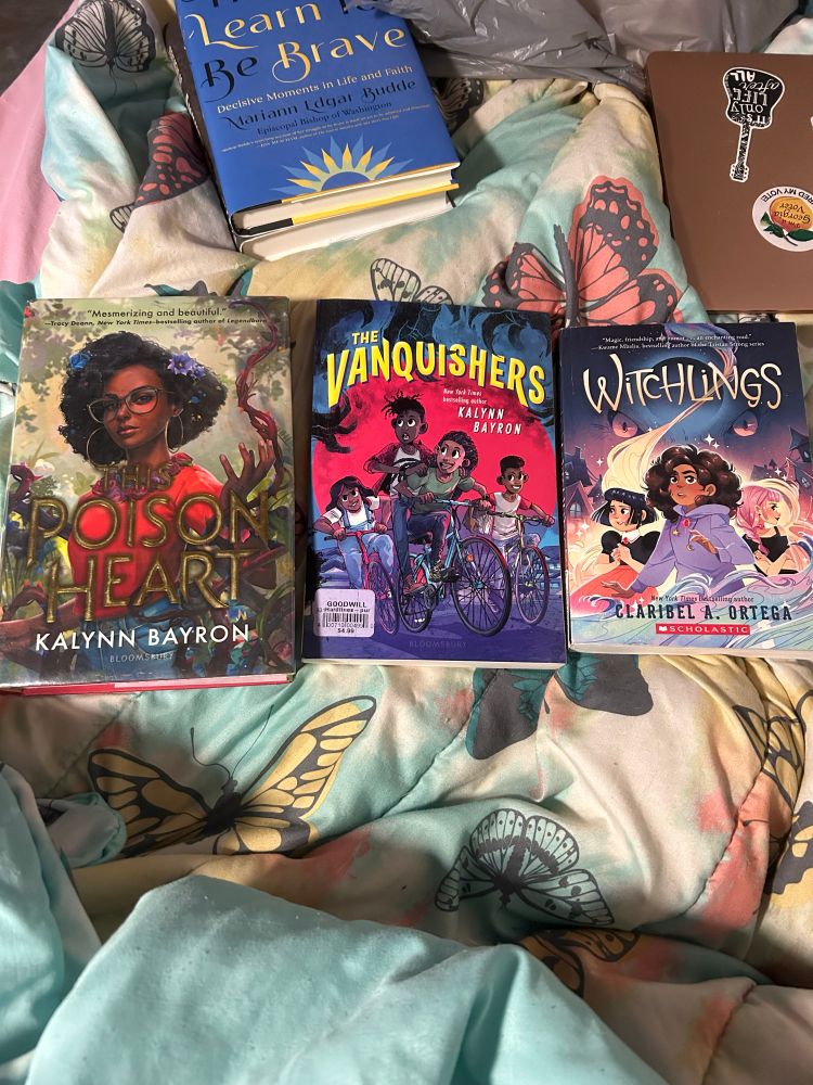 3 books together on my bed. Gorgeous variety of middle grades & YA. I can’t do the cover art justice w my low energy brain. 
Here’s the titles: 
This poison heart by Kalyn Bayron 
The Vanquisher by Kaylyn Bayron 
Witchlings by Claribel A. Ortega 
