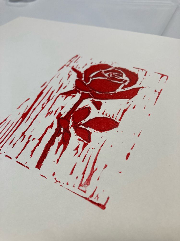 Linocut print of a rose in red ink