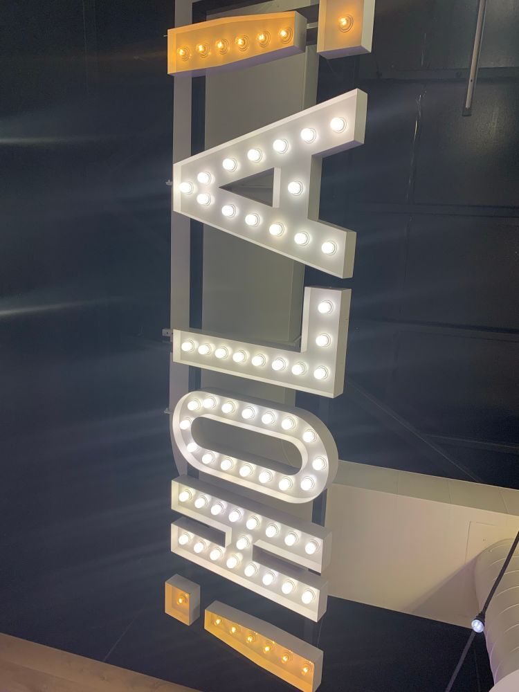 "HOLA!" Neon sign hanging from the roof of a taco bell