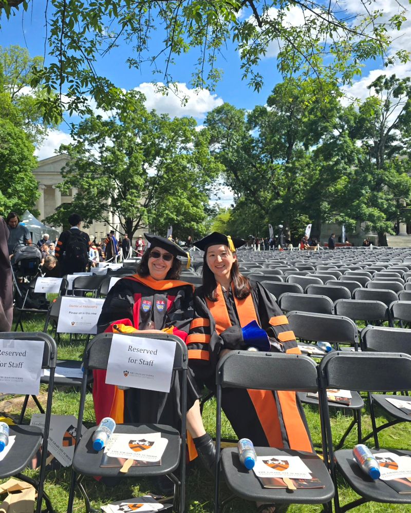 Olga and Sunnie sitting together at the hooding ceremony