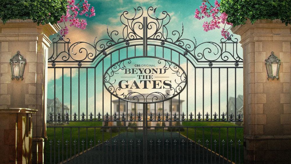 an ornate front gate with pink flowers obscuring the the view beautiful mansion, beyond the gates and cbs original is written on the gate