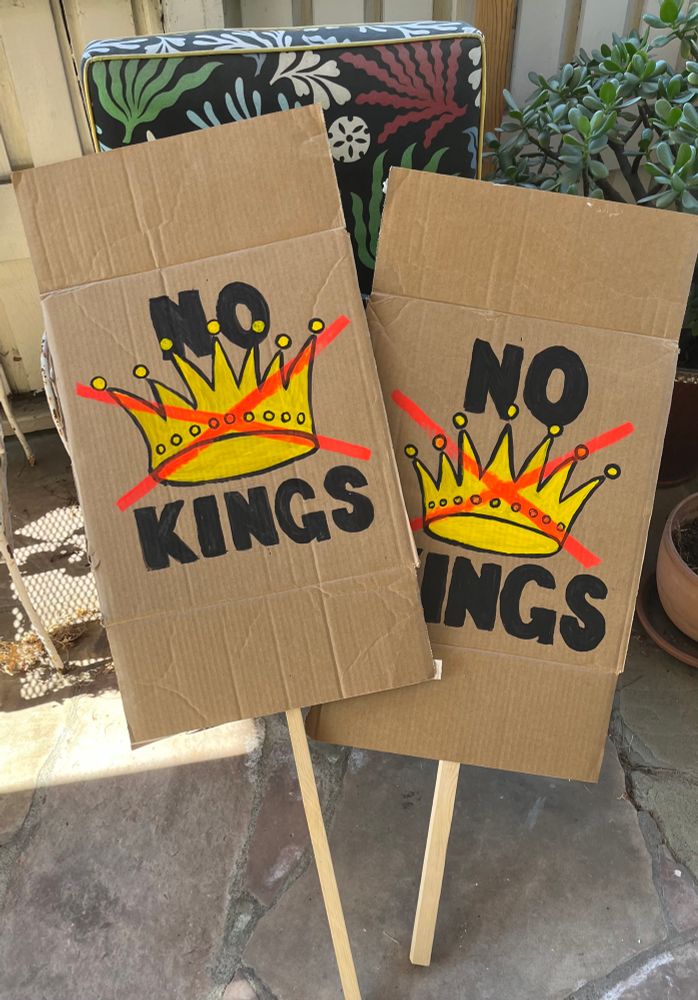 Cardboard sign stating “ No Kings” with an illustration of a gold crown and a red ❌ through it. 
