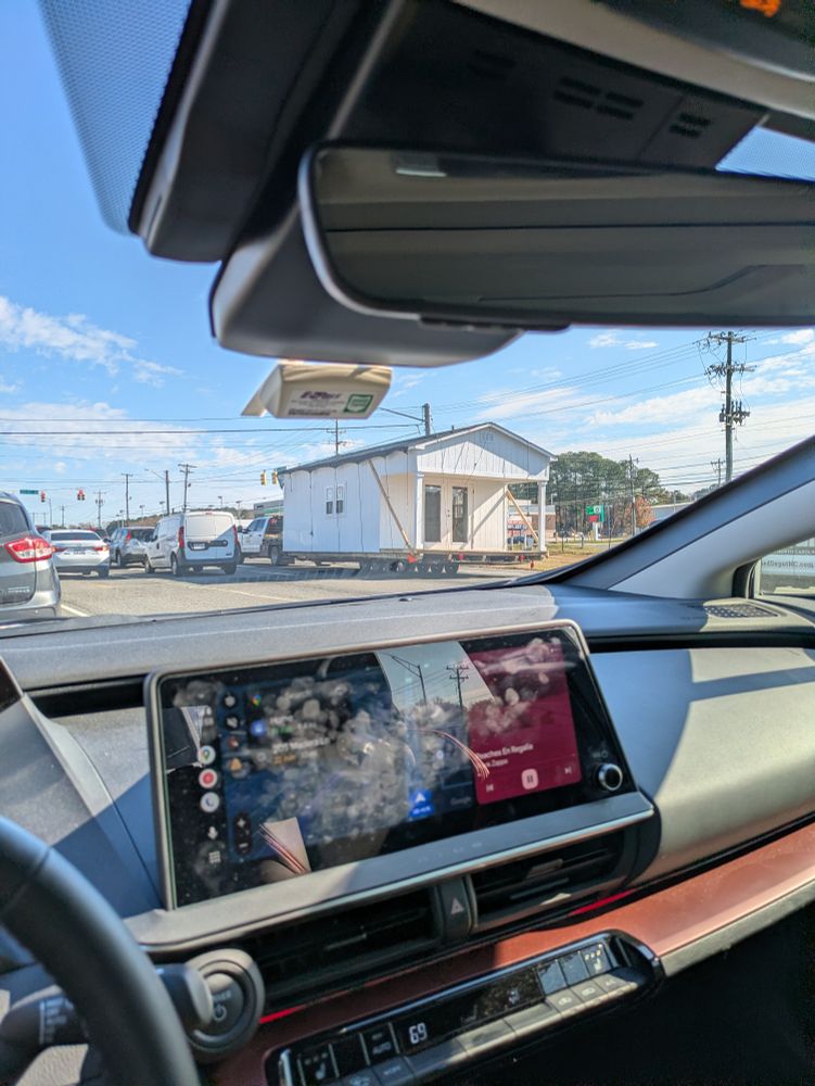 A large shed being towed by a truck
