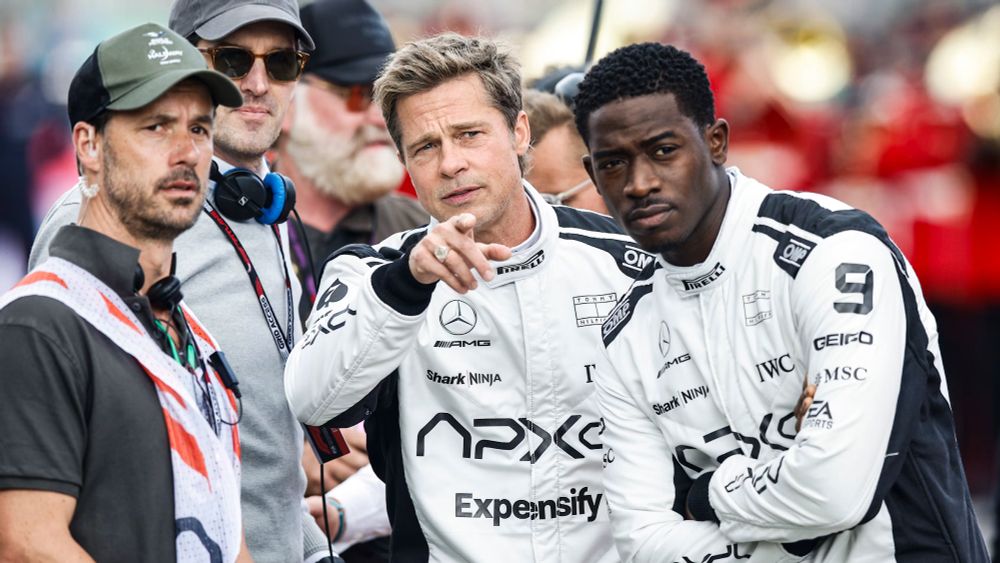 Camera set shot from F1.

Brad Pitt (middle) and Damson Idris (right) point into the distance, as Brad talks to someone on the film set.