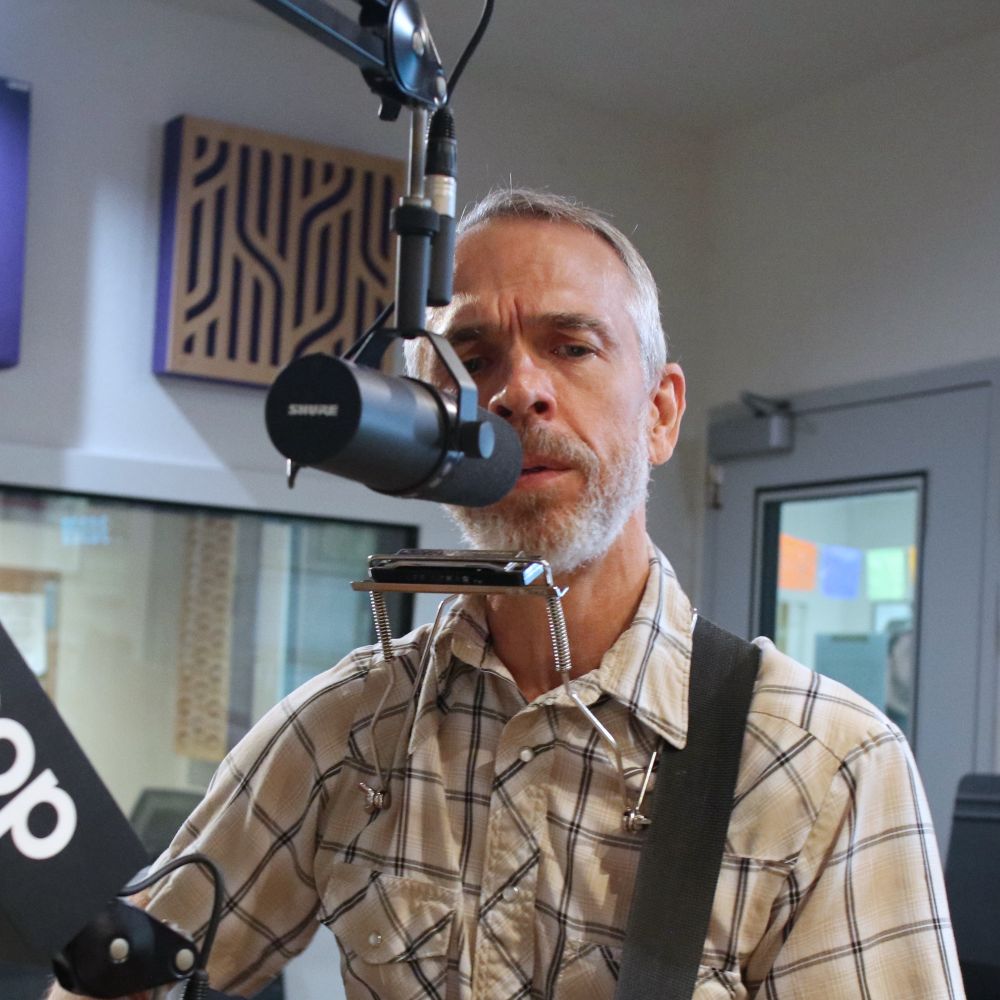 Dan Whitaker singing into KOOP studio Microphone.