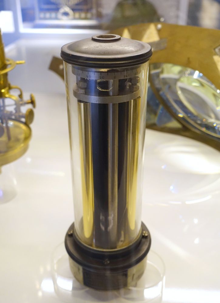A photo of Dalen's sunlight valve, which looks like a set of tubes in a glass case. This valve worked by means of a set of metal rods, one of which was blackened while the others were polished. When the blackened rod absorbed enough heat from the Sun, it would expand and close the valve. At dusk, or in foggy conditions, the blackened rod would return to the temperature of the others, contract, and open the valve.