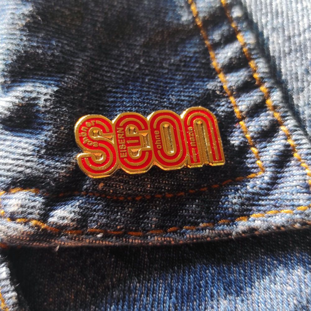 Jeansjackenkragenspitze mit "Schöner Eisern Ohne Nazis" Pin 