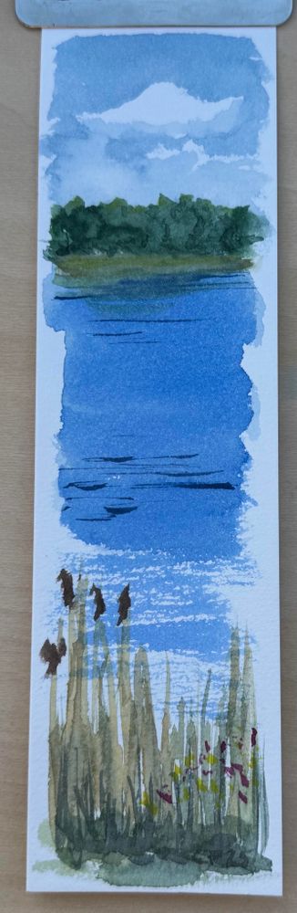 Lesezeichen Aquarell: Blick über die Schlei auf das gegenüberliegende Ufer. Büsche am Ufer, Wolken am Himmel und Schilf im Vordergrund.