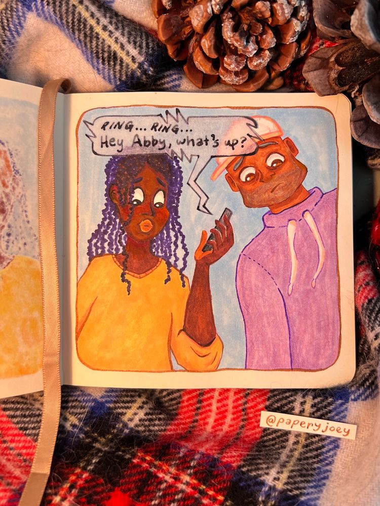 A square book is opened to show the same two people from the previous page now looking down at something. The girl on the left is holding a phone and calling someone, who then answers. 

The speech bubble coming from the phone reads, “RING… RING… Hey Abby, what’s up?”

The book is surrounded by a tartan scarf and pinecones, and at the bottom right is the artist handle @paperyjoey
