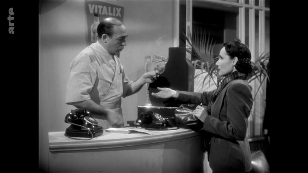 Dolores del Río renunciando a su miserable trabajo de manicurista por acoso sexual: el patrón (un tirano) le está dando su magra liquidación, de donde deduce las herramientas de trabajo: Dolores no podrá pagar su renta y además es navidad (fotograma extraído de la película La Otra, de Roberto Gavaldón, 1946)